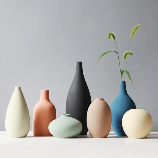 Set of colorful ceramic vases on a light surface with a gray background